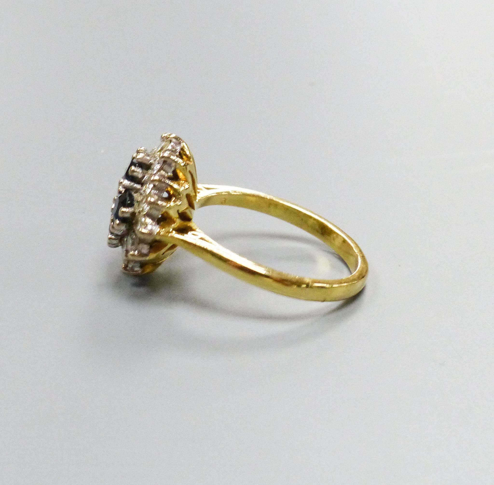 A modern 18ct gold, sapphire and diamond set diamond shaped cluster ring, size M/N, gross 6.1 grams.